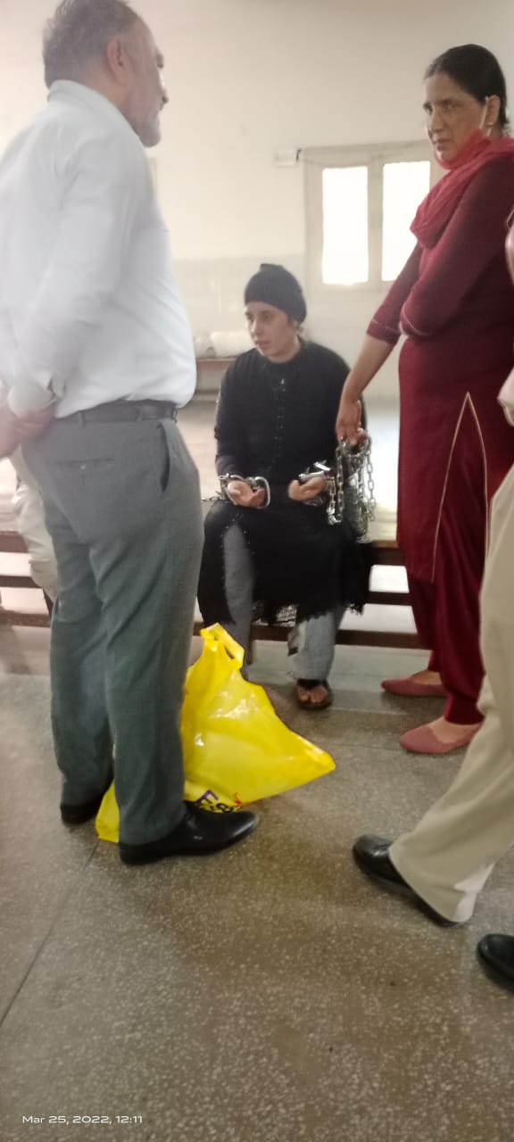 Legal support for a woman prisoner during a court hearing, March 2022